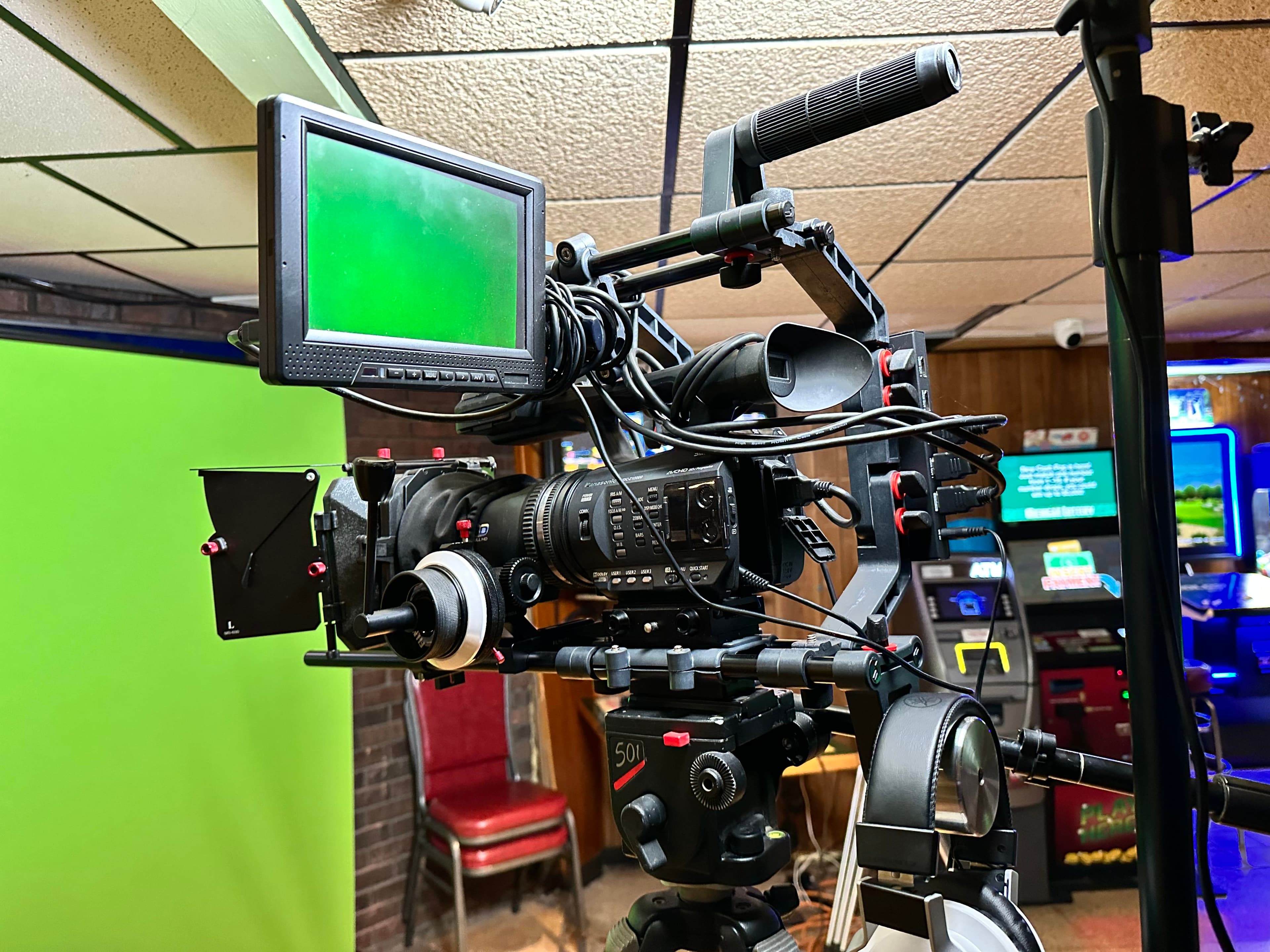 A professional cinema camera on a tripod with a monitor attached