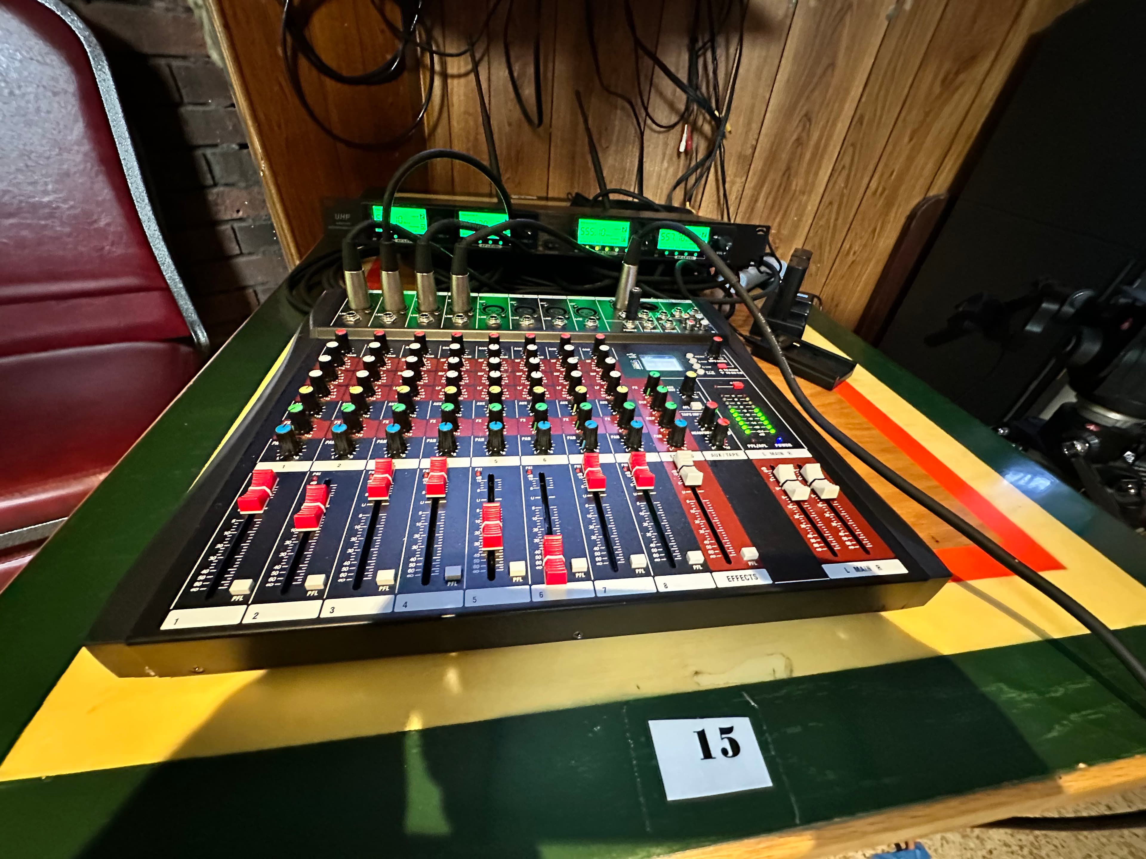 A multi-channel audio mixing console set up on a table at an event